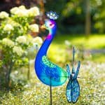 Girouette en forme de paon planté dans un jardin.